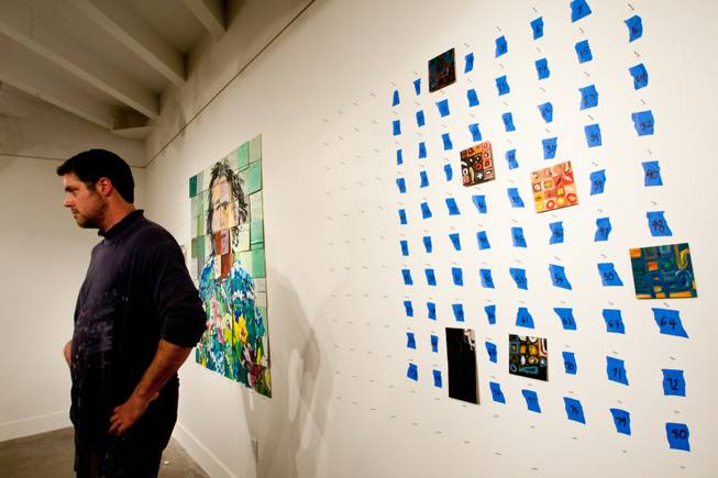 Artist Jason Adkins watches guests create individually painted squares to be used to create another iconic image of art to be displayed in P3Studio during his in-house residency at The Cosmopolitan of Las Vegas Friday, January 11, 2013.  Featured on the left is a mug shot of Nick Nolte previously created by studio participants.